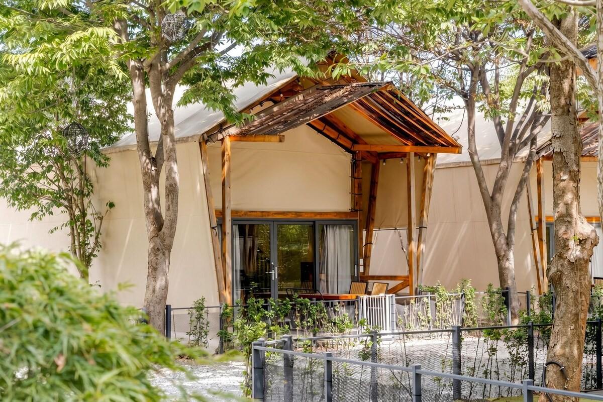 Een traditioneel Japans gebouw met een houten constructie, een glazen schuifdeur en een omheinde tuin.