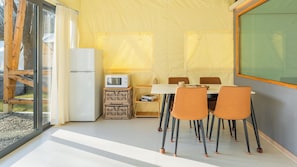 A dining area with a table, chairs, a refrigerator, and a microwave. - Gapyeong High Mong Glamping & Camping (Gapyeong)