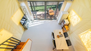 A compact kitchen with a dining area, a staircase, and a view of the outdoor patio. - Gapyeong High Mong Glamping & Camping (Gapyeong)
