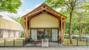 A wooden cabin with a large entrance and a covered porch area.