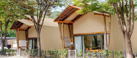 Una hilera de edificios modernos de una sola planta, con amplias ventanas y vigas de madera.