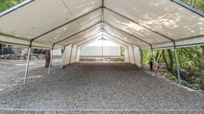 A covered outdoor area with a gravel floor, metal poles, and a white canopy. - Gapyeong High Mong Glamping & Camping (Gapyeong)
