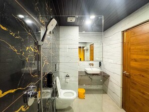 A modern bathroom with a glass-enclosed shower, a white toilet, and a wooden door.