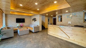 Un área de recepción con un mostrador de madera, un sofá y una mesa de centro.