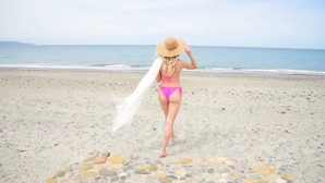 A beach scene with a person in a bikini and hat walking on the sand. - Cassiopeia Penthouse (Pyrgos Psilonerou)