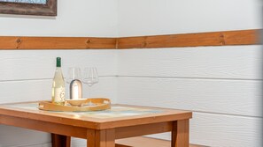 A wooden table with a bottle of white wine, two glasses, and a tray. - Pohang In The Blue Spa Pension (Pohang)
