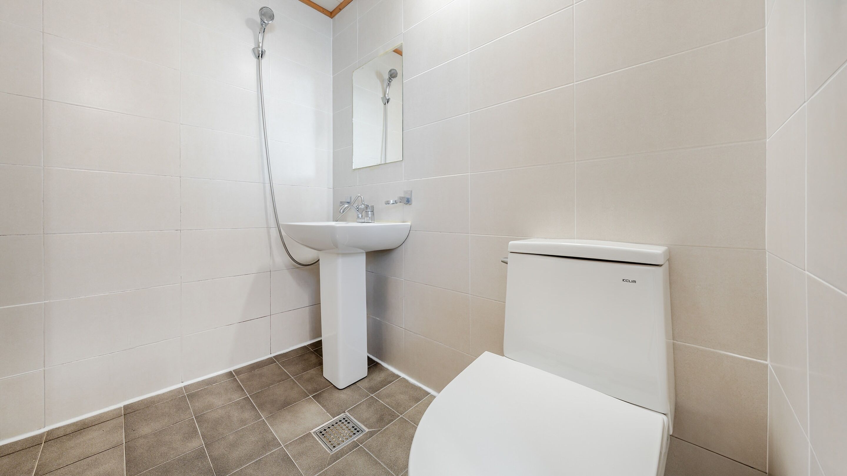 A bathroom with a toilet, sink, and shower.