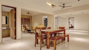 Un amplio salón con una mesa de comedor de madera, sillas y un ventilador de techo.