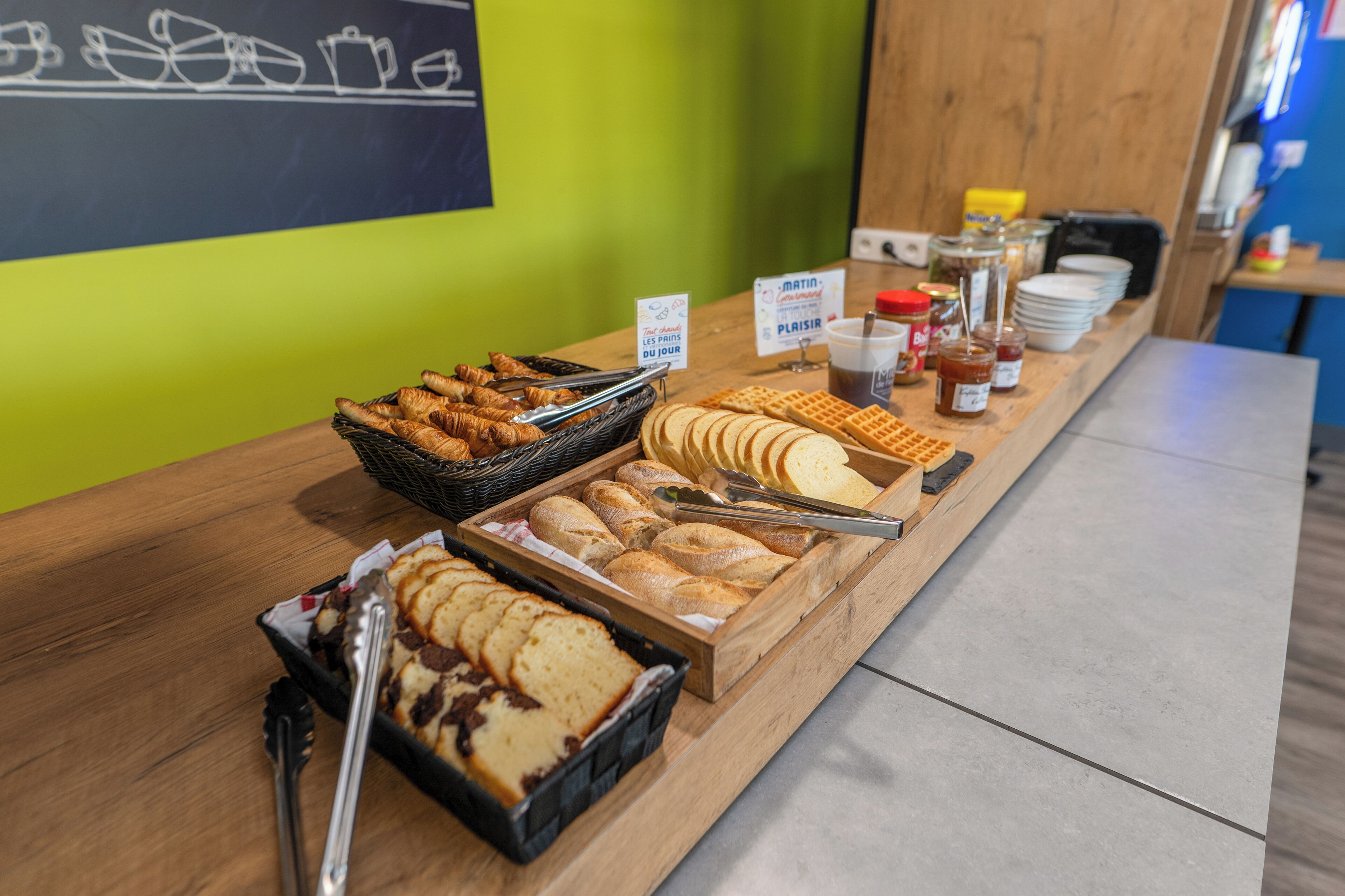 A breakfast buffet with various pastries and bread.