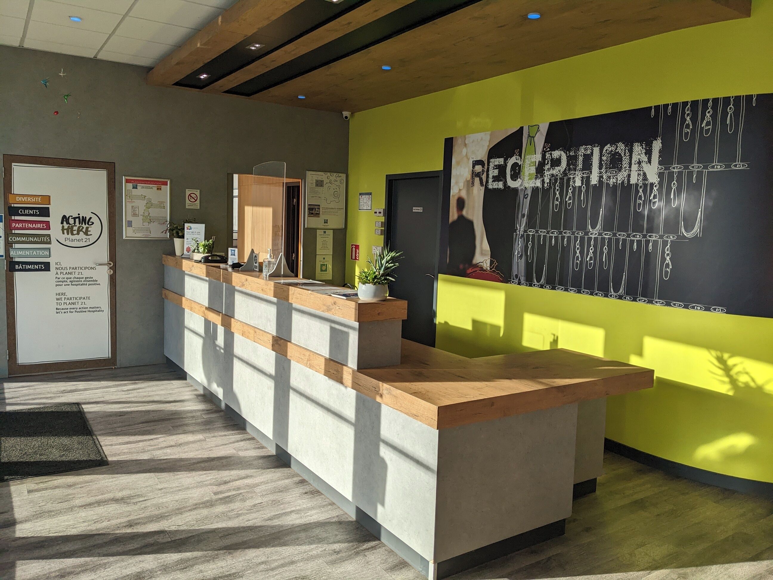 A reception area with a wooden counter, a large reception desk, and a wall with a 'RECEPTION' sign.