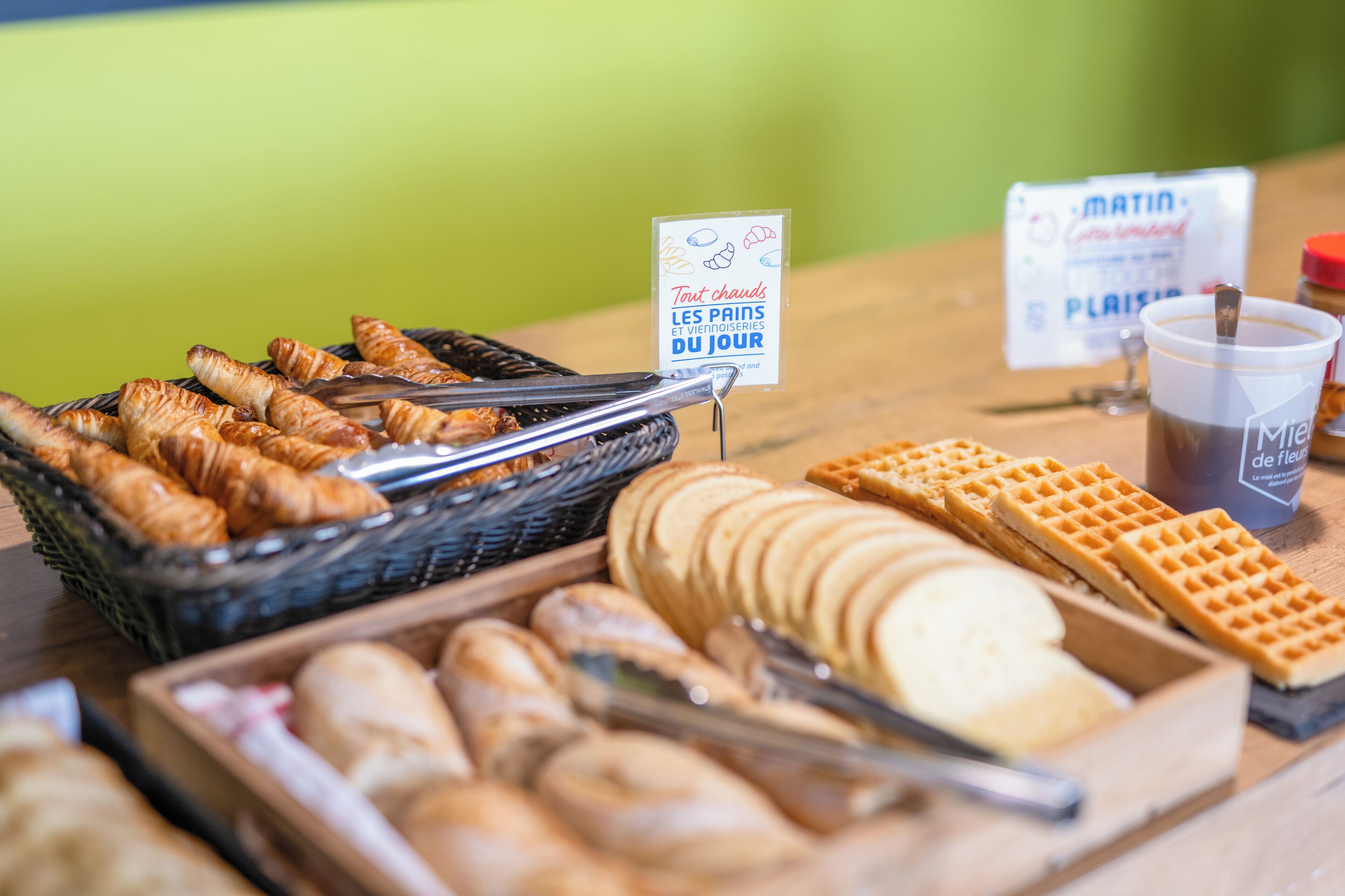 A breakfast buffet with croissants, waffles, and other pastries.