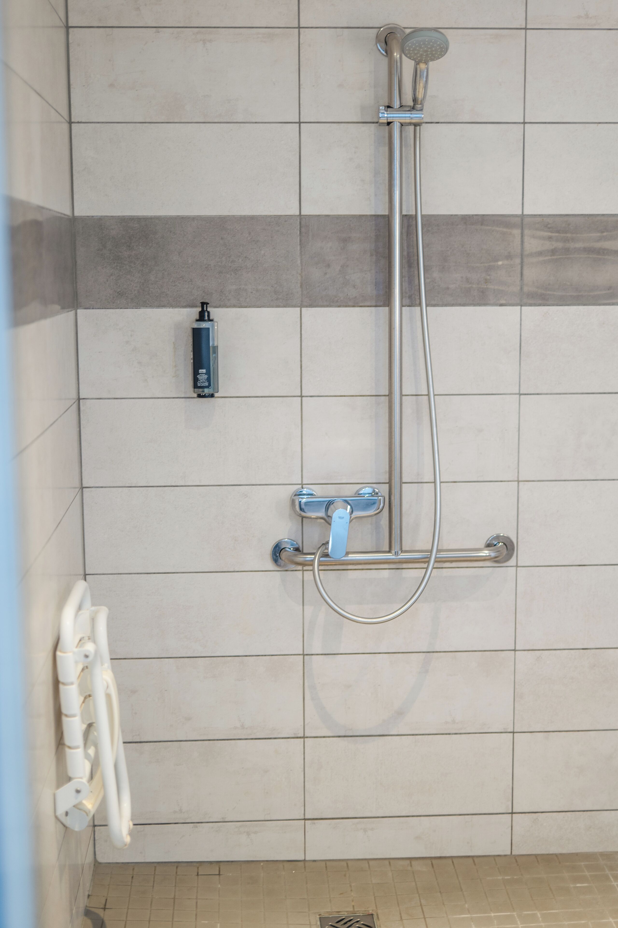 Ducha con cabezal de ducha de mano y grifo empotrado.