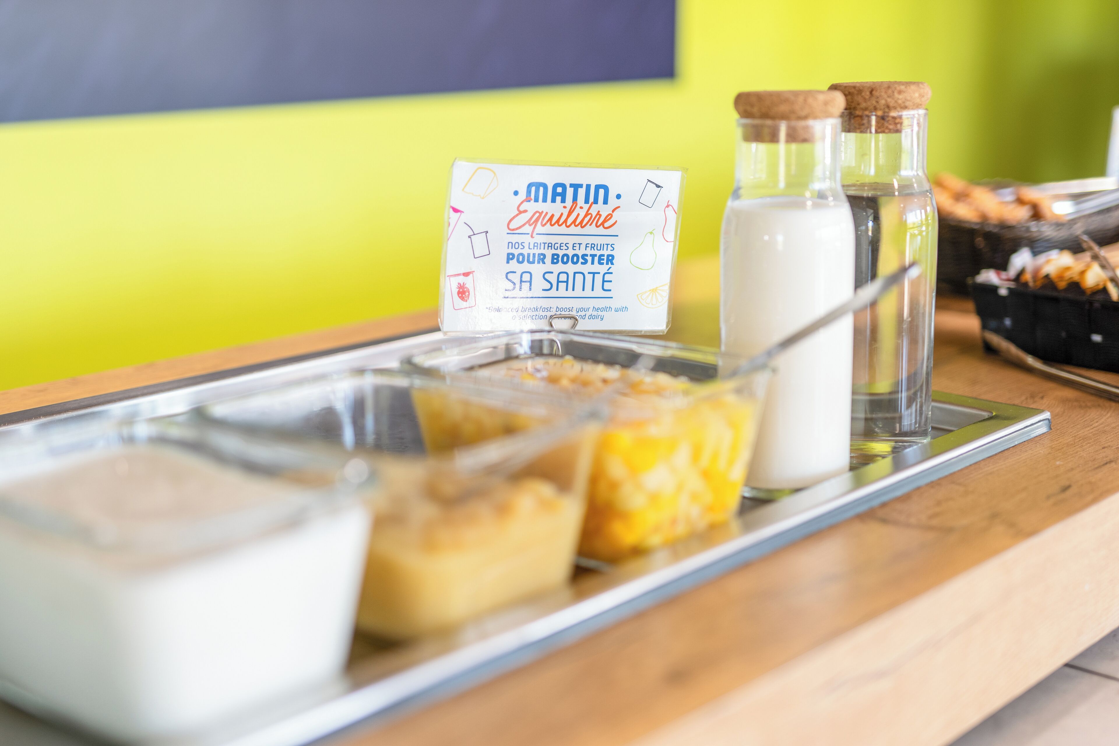 Un bufé de desayuno con diversos alimentos y cartones de leche en una bandeja.
