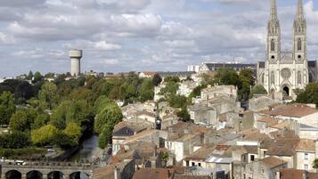 Eine historische Stadt mit einem markanten Kirchturm, einem Wasserturm und einer Brücke.