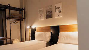 A hotel room with two beds, a wooden headboard, and a shelf with towels. There are three framed pictures on the wall. - ibis Puerto General San Martin (Puerto General San Martín)