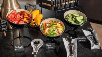 Una mesa de buffet con ensaladas y verduras frescas.