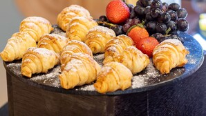 A selection of pastries and fresh fruits on a wooden table. - Ibis Styles Fortaleza Giga Mall (Fortaleza)