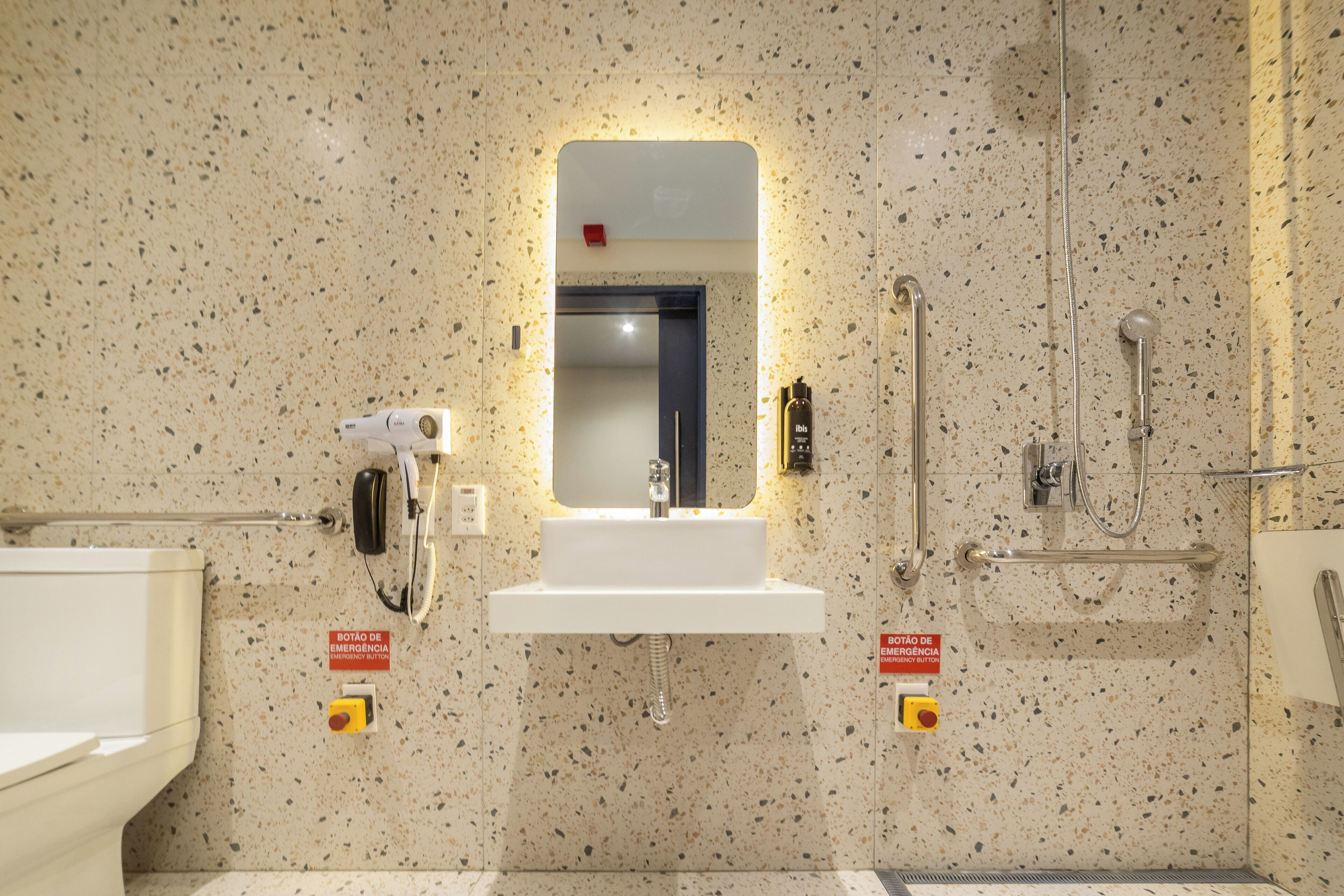 A bathroom with a sink, mirror, and shower.