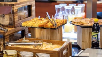 Un bufé de desayuno con diversos alimentos y acompañamientos.