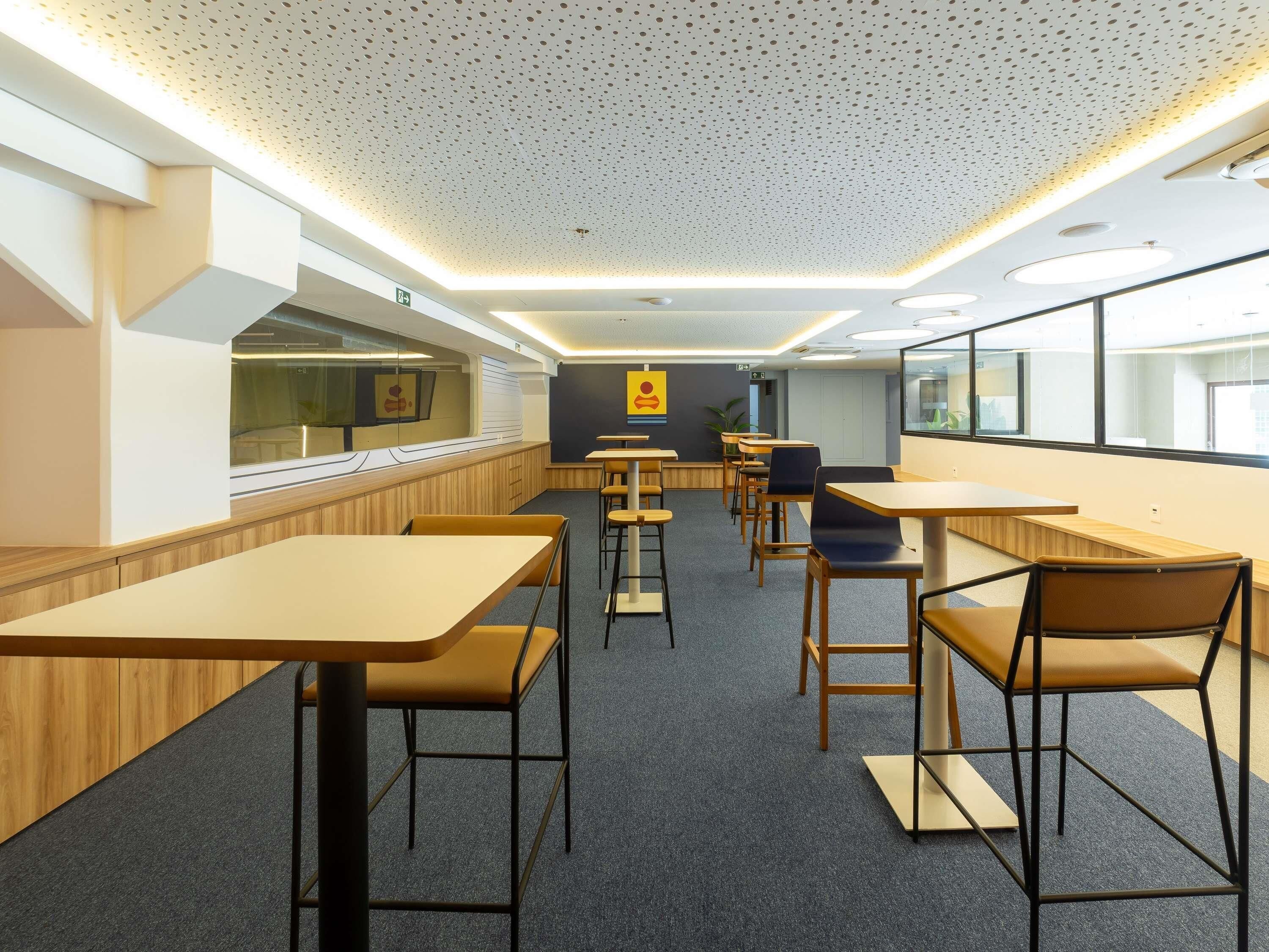 A modern interior with tables and chairs arranged for dining.