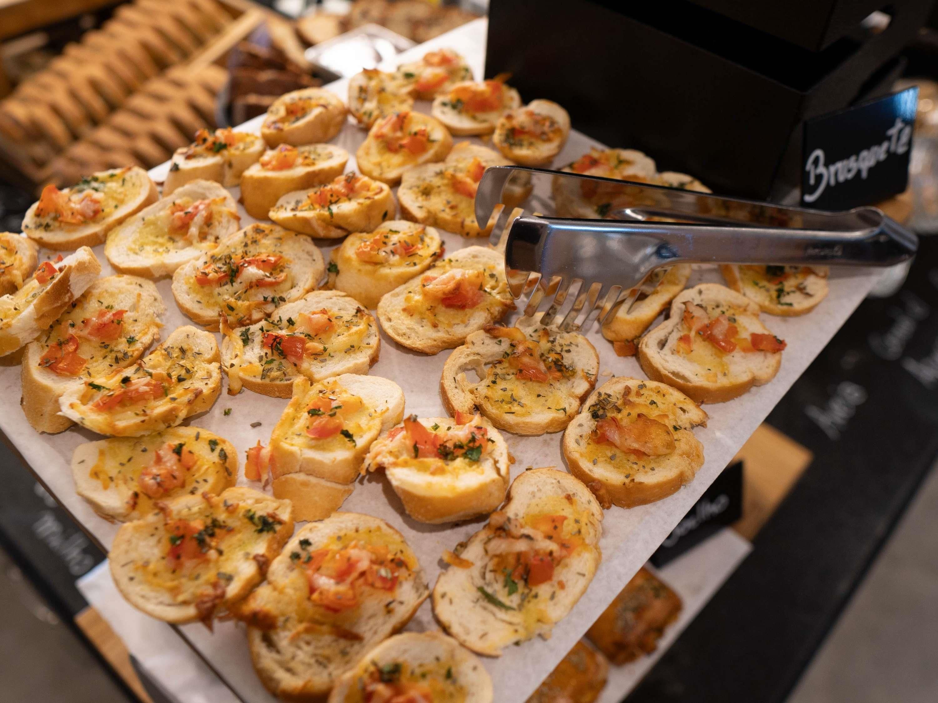 A tray of appetizers with a fork and tongs.