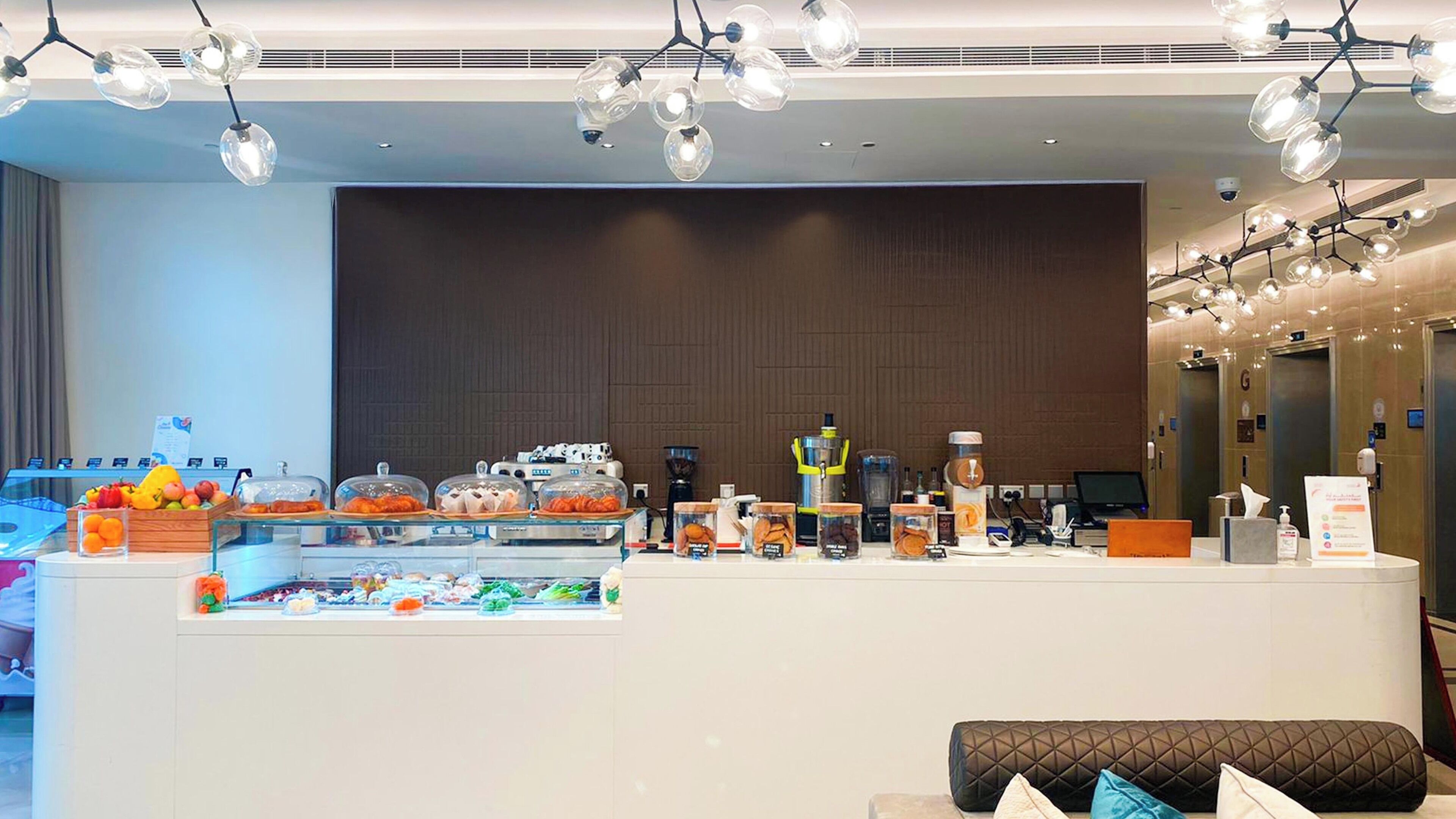 A hotel reception area with a buffet counter displaying various food items and a coffee machine.
