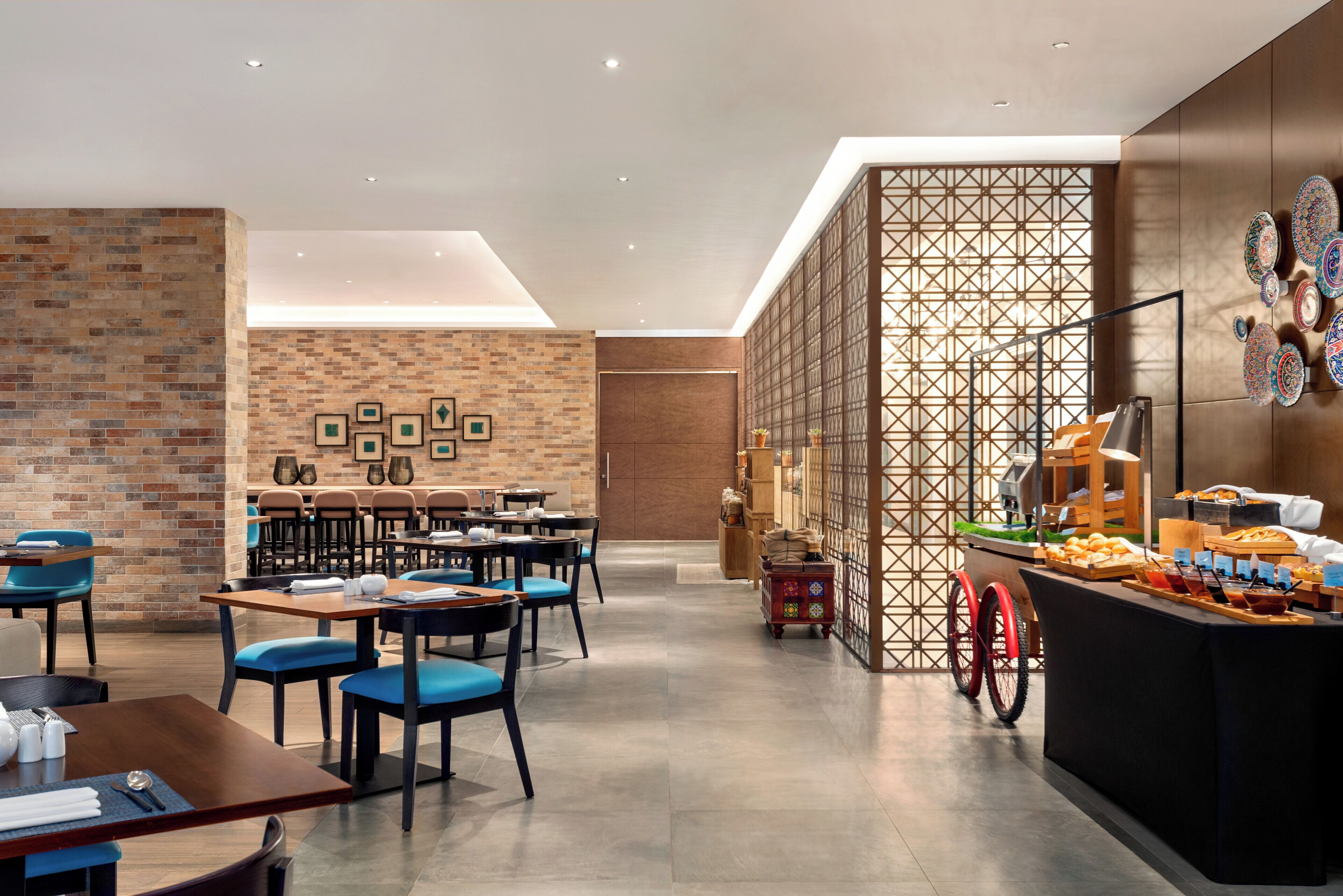 Een modern restaurant met bakstenen muren, houten meubels en een buffet.