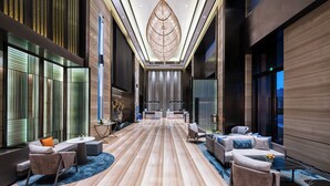 A spacious lobby with a central seating area, a reception desk, and a large decorative ceiling feature. - Novotel Kunshan Yangcheng Lake (Suzhou)