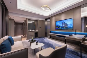 Suite superior, 1 cama de matrimonio grande | Zona de estar | Televisión LED de 65 pulgadas con canales por cable, un futbolín