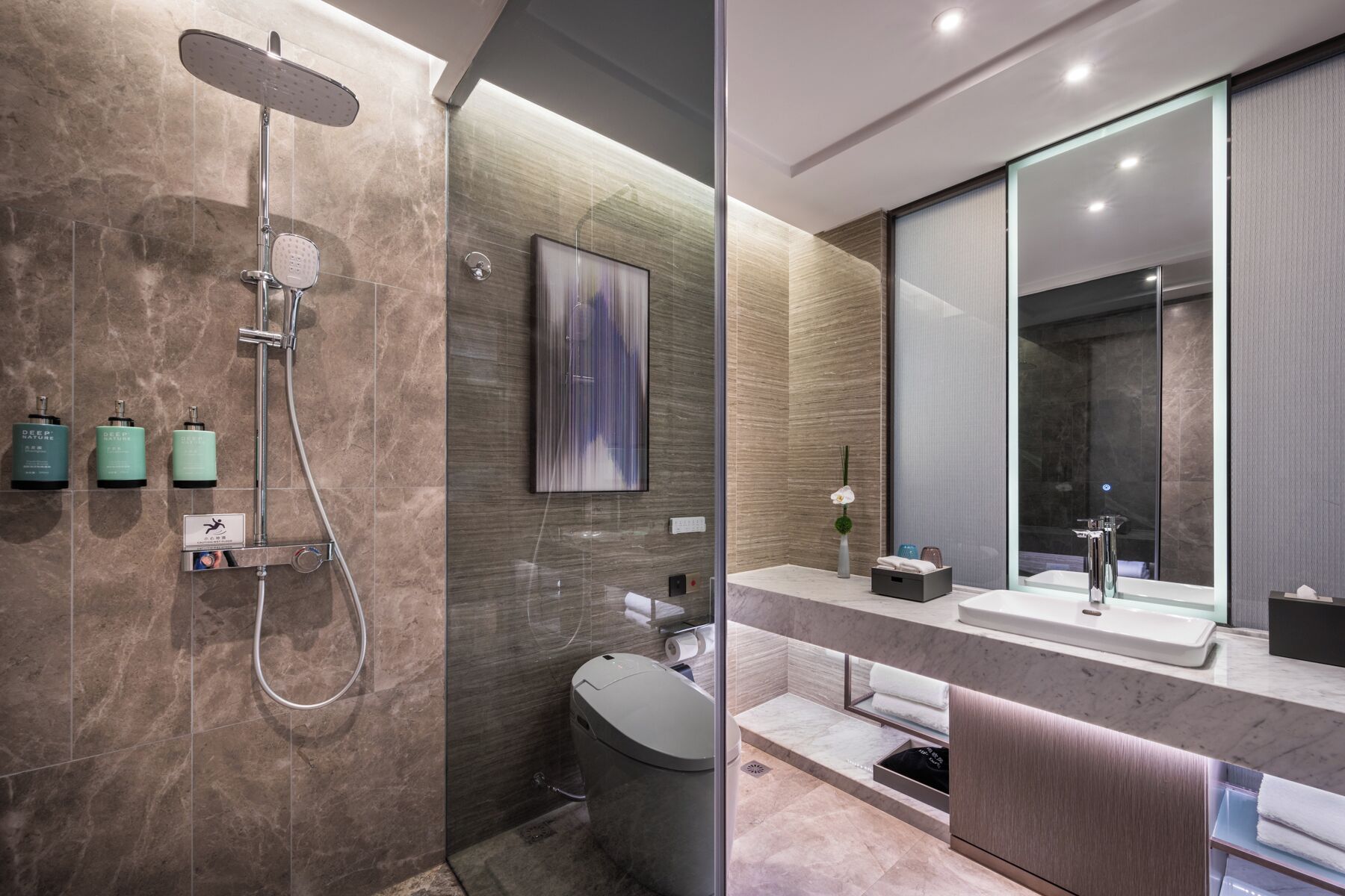 Un baño moderno con ducha, inodoro y lavamanos.