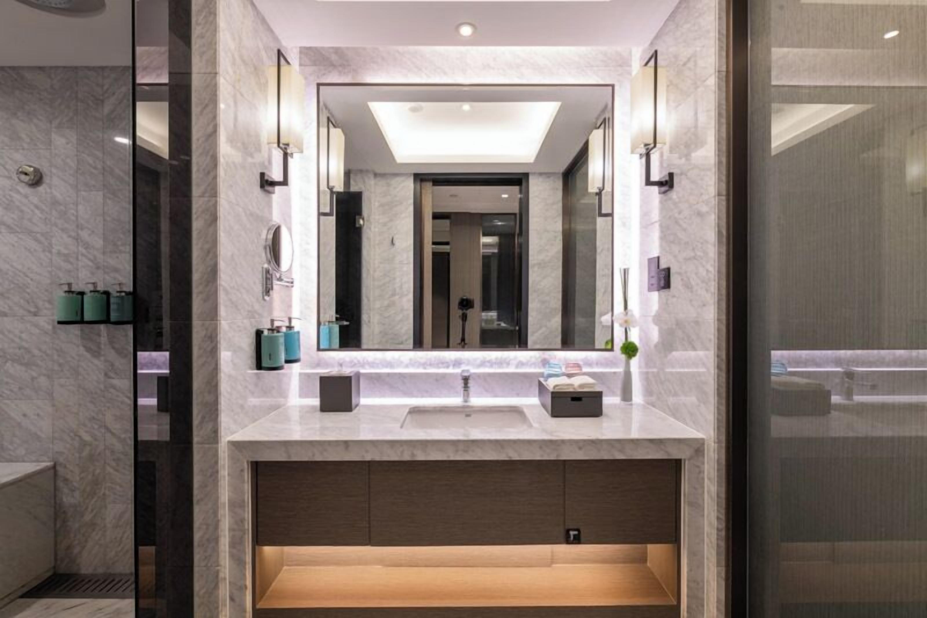 A modern bathroom with a large mirror, a sink, and a vanity.