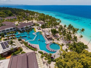 Un complexe hôtelier doté d’une grande piscine, d’une plage et offrant une vue sur l’océan.
