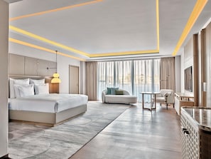 A modern hotel room with a large bed, a sofa, a small table, and a TV. - Swissôtel Tashkent (Tashkent)