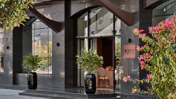 Un bâtiment moderne avec une entrée en verre, des plantes en pot et une enseigne indiquant un espace dédié aux banquets.