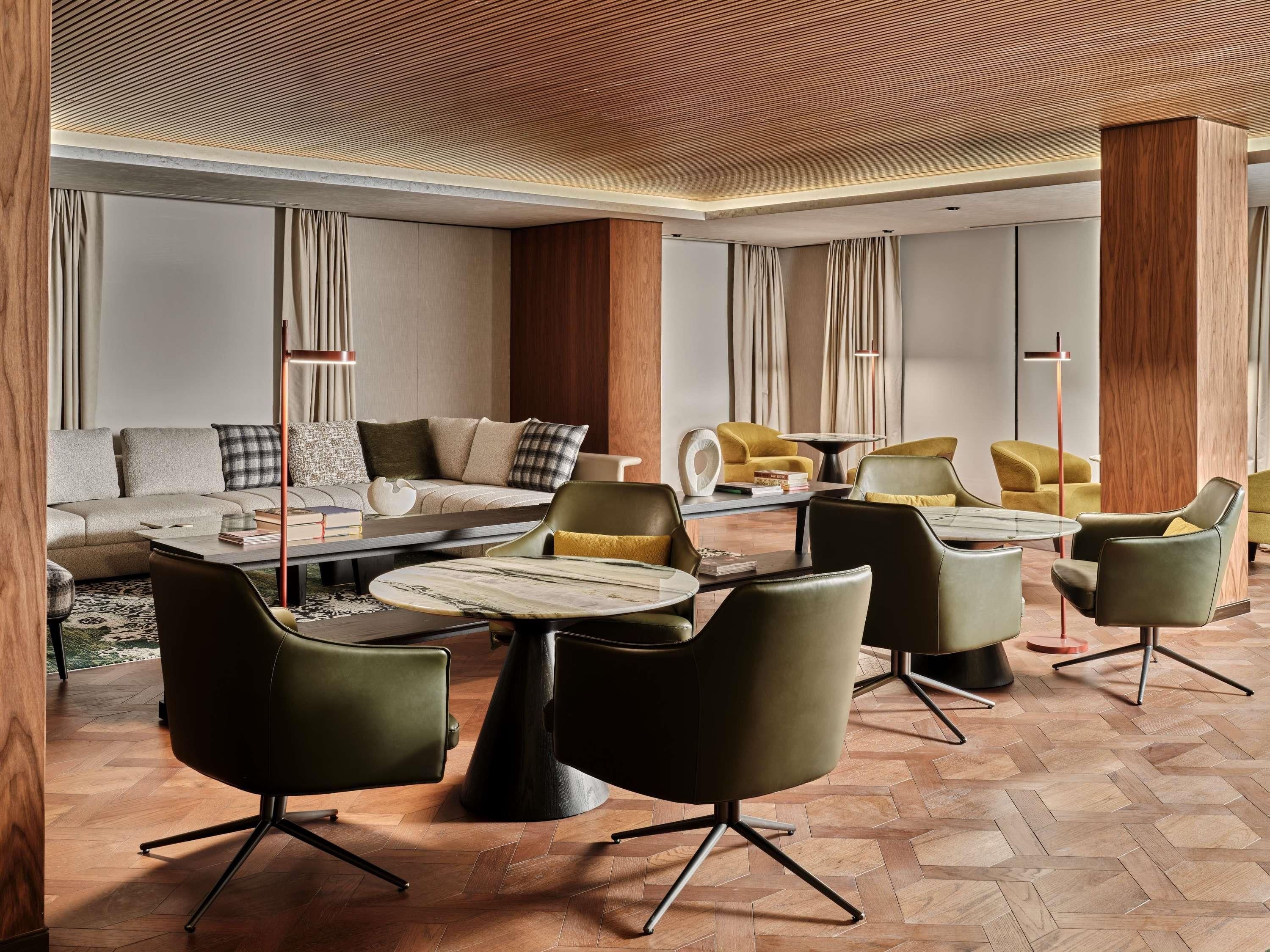 A modern living room with a sectional sofa, a coffee table, and multiple chairs.