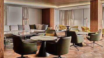 A modern living room with a sectional sofa, a coffee table, and multiple chairs.