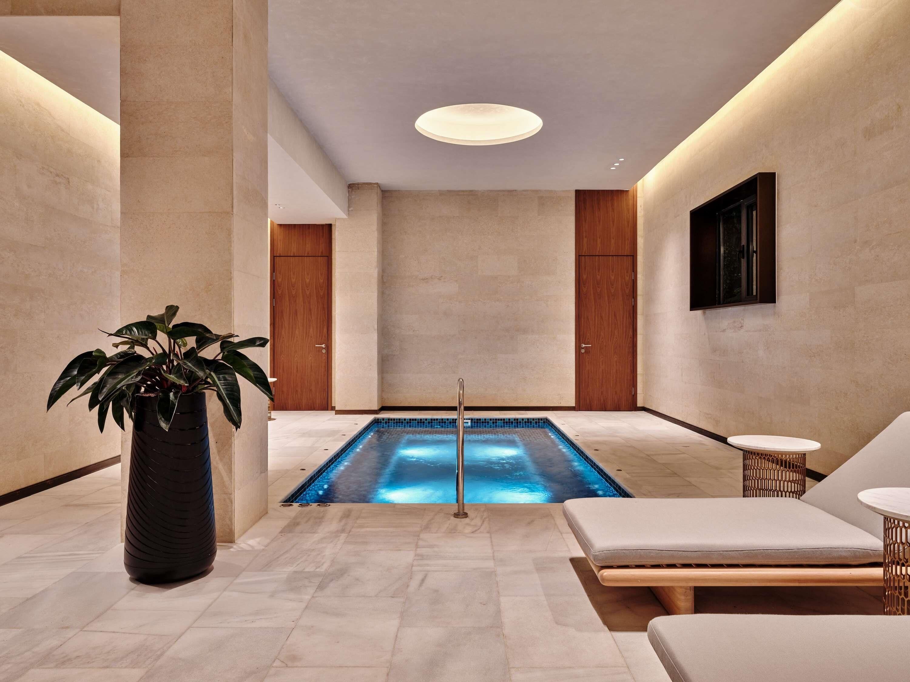 Una piscina techada, sillones reclinables de piscina