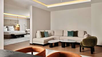 A modern living room with a sectional sofa, a round coffee table, and a dining table with chairs.