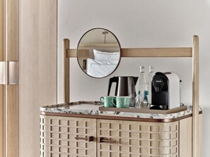 A bathroom with a wooden cabinet, a mirror, a coffee maker, and a kettle. - Swissôtel Tashkent (Tashkent)