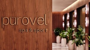 En vägg av trä med texten ”purovel spa & sport”, vilket visar att det är ett spa- och sportcenter.