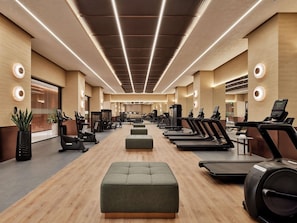 A modern gym with treadmills, elliptical machines, and weight equipment. - Swissôtel Tashkent (Tashkent)