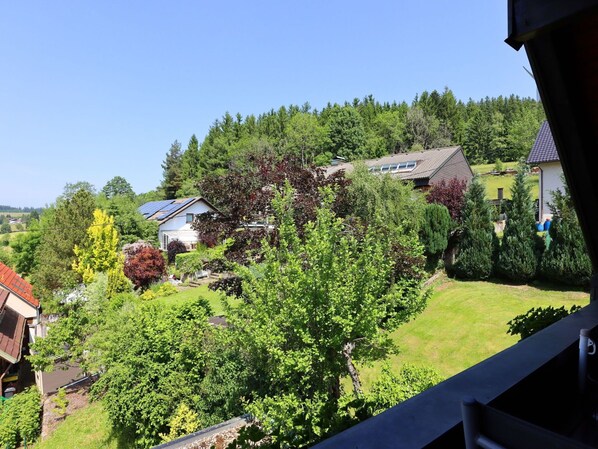 A residential area with houses surrounded by lush greenery and trees.