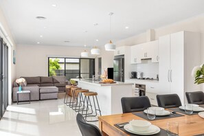 Una cocina moderna con armarios blancos, electrodomésticos de acero inoxidable y una isla central.