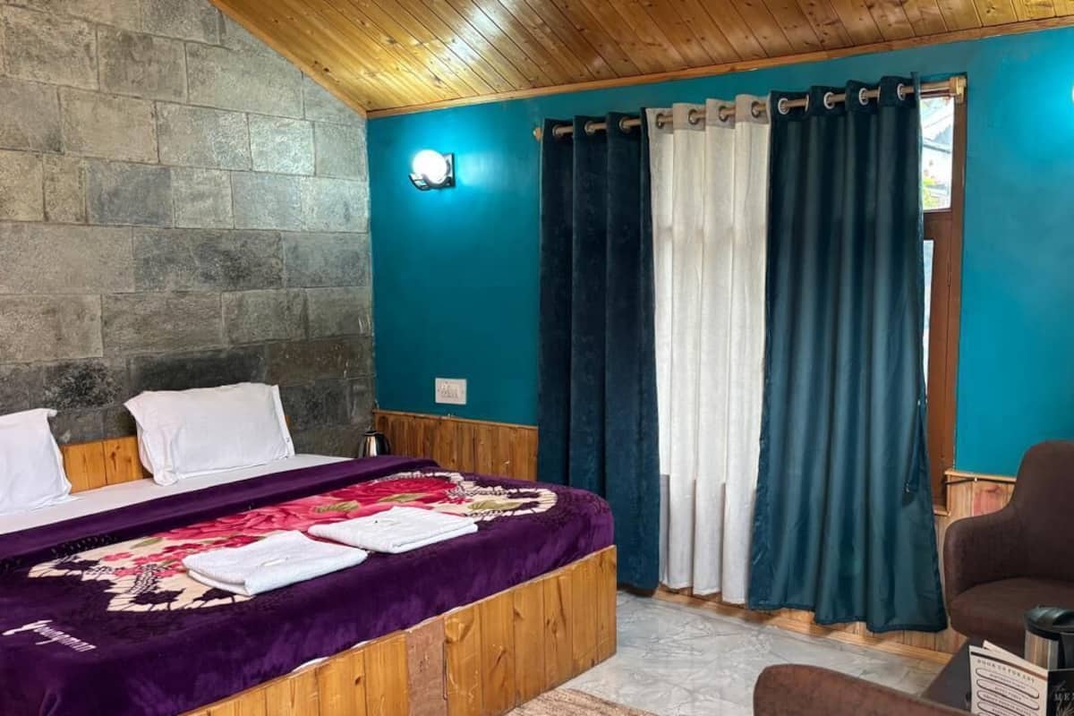 A room with a bed, a chair, and a table with a menu.