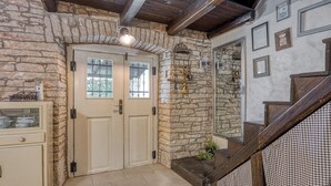 A stone-walled entrance with a wooden staircase leading to a second floor. - Villa Capadinka With Whirlpool (Marcana)