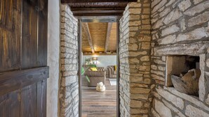 A narrow stone-walled hallway with a wooden door and ceiling beams. - Villa Capadinka With Whirlpool (Marcana)