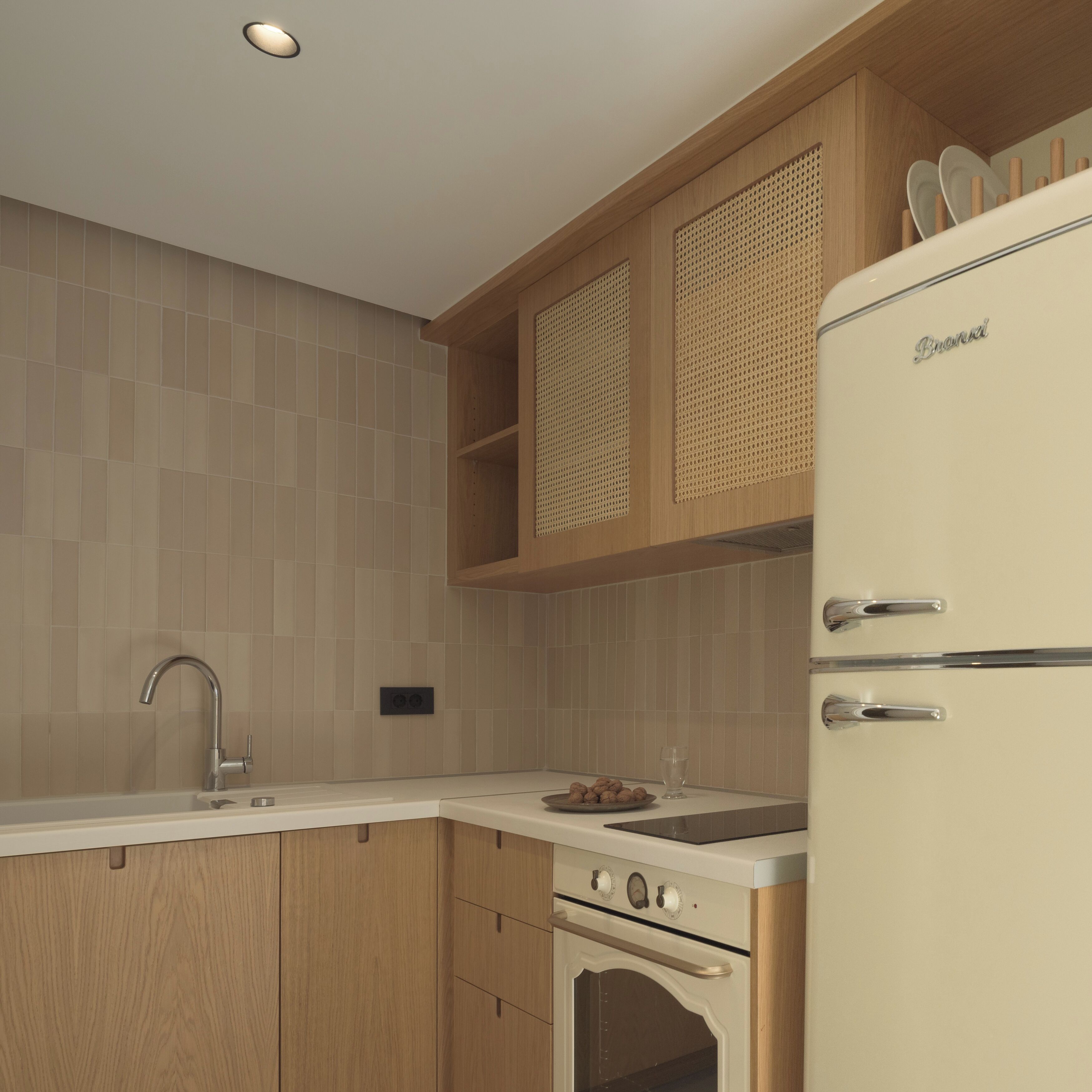 A modern kitchen with wooden cabinets, a stainless steel sink, and a white refrigerator.