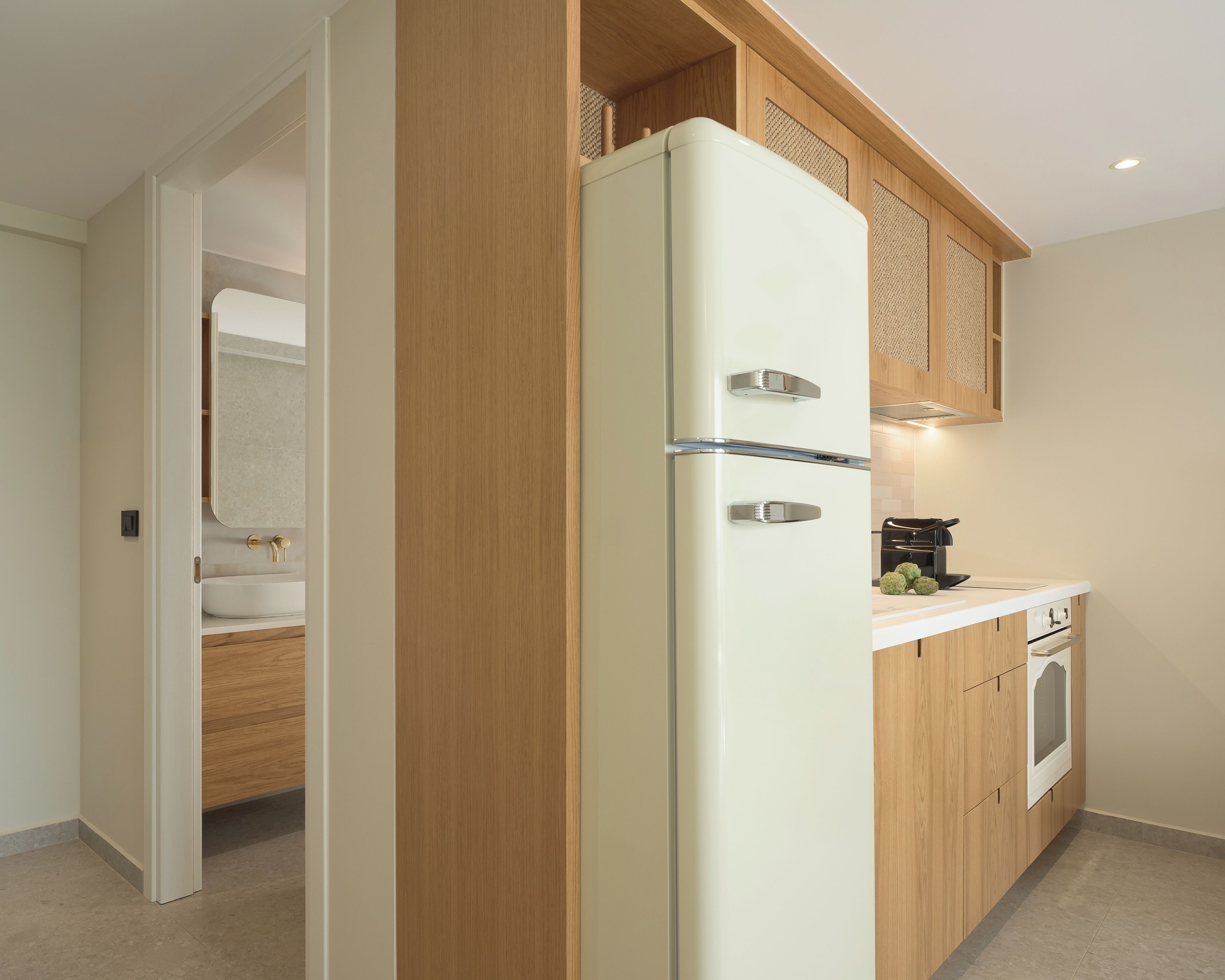 Eine moderne Küche mit Einbaukühlschrank, Holzschränken und einer Arbeitsplatte mit Kaffeemaschine.