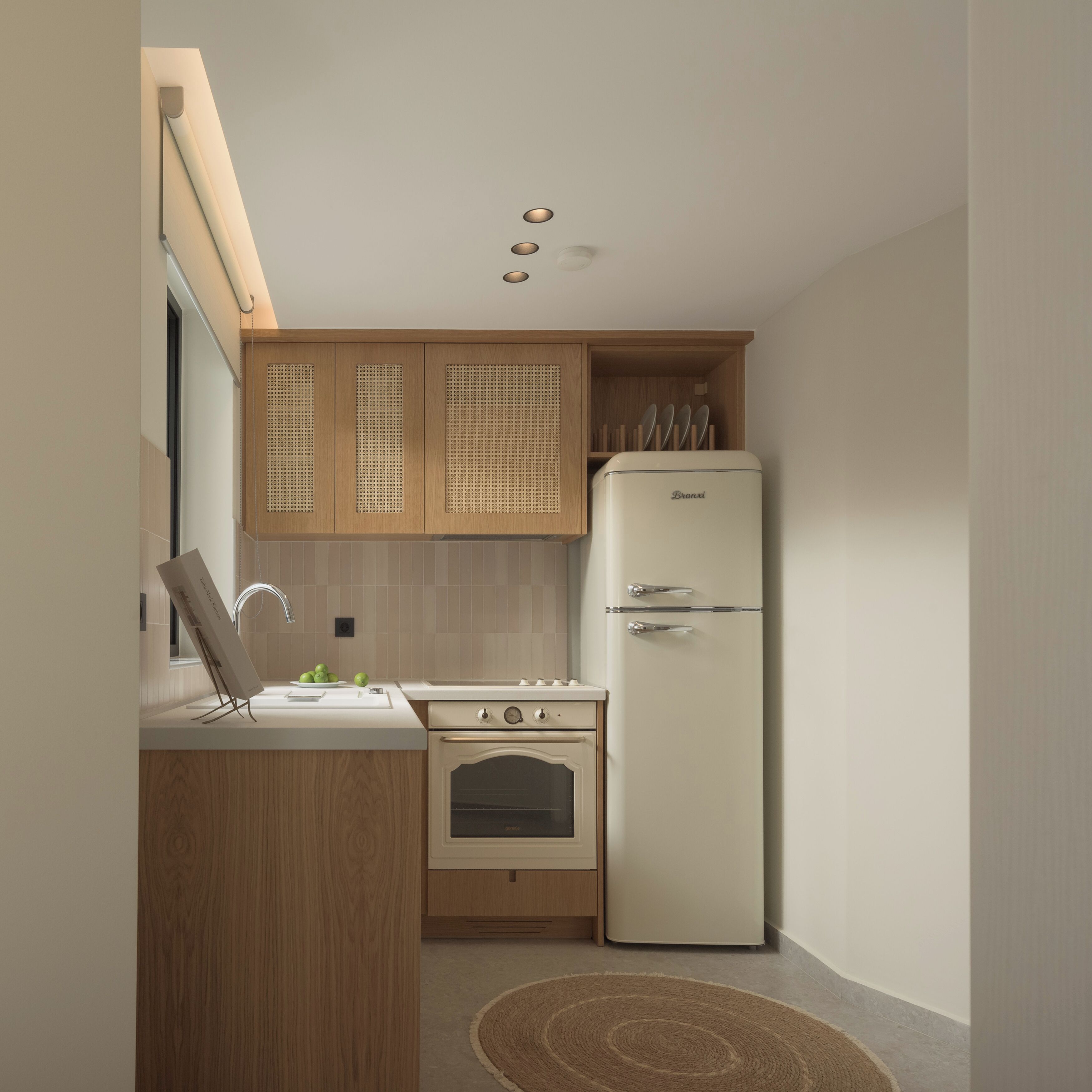 Eine kleine Küche mit Holzausstattung, einem weißen Kühlschrank und einem eingebauten Backofen.