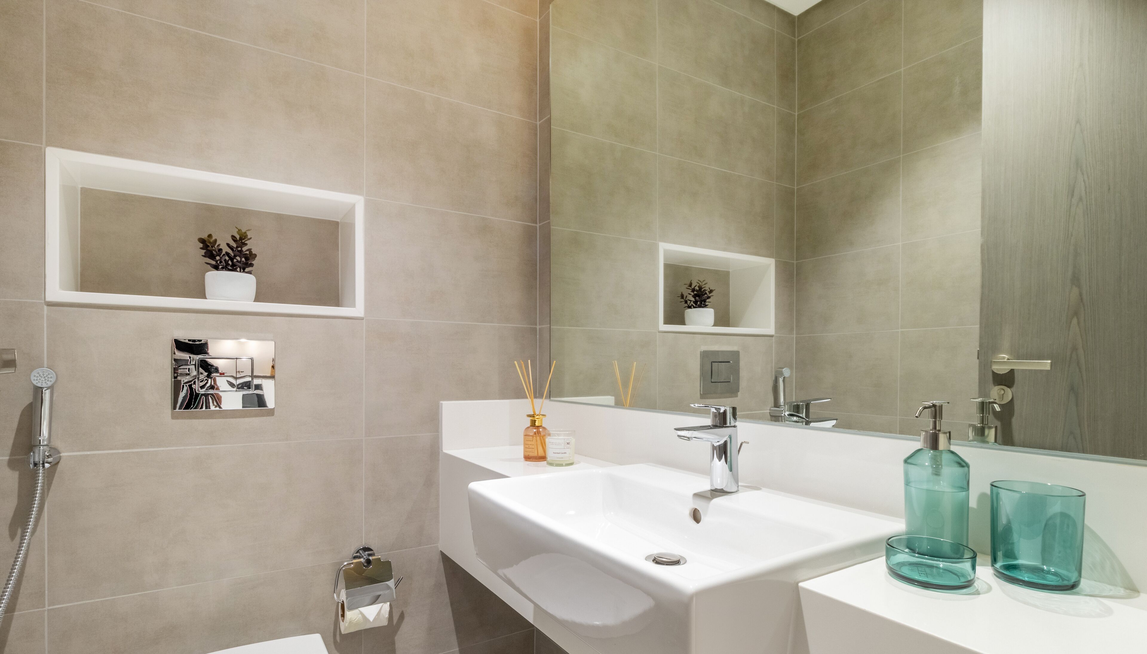 A modern bathroom with two sinks, a large mirror, and a shower.
